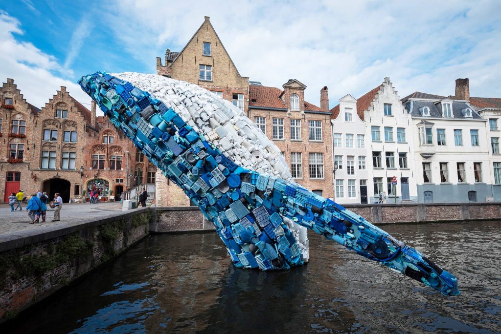 Triennial artwork of humpback whale in plastic jumping out of a Bruges canal